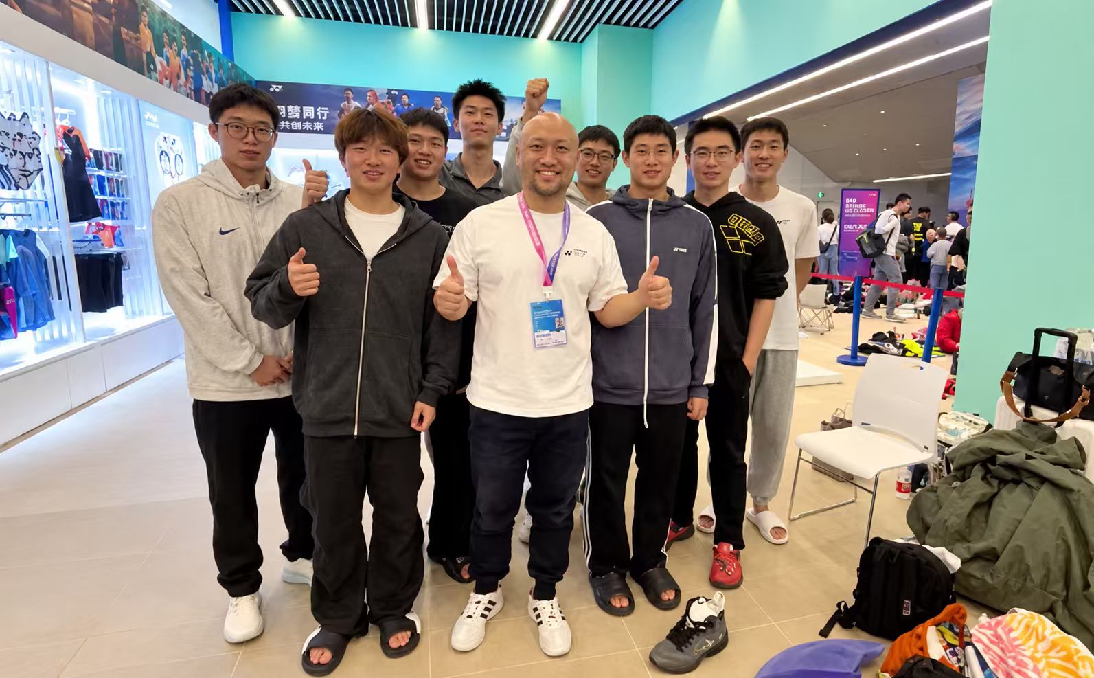 Frank张伟与多位活动参与者在赛事场馆内合影